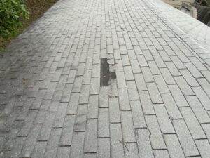 Grey shingle roof with missing and damaged sections at Dolan Roofing & Construction in San Antonio, TX